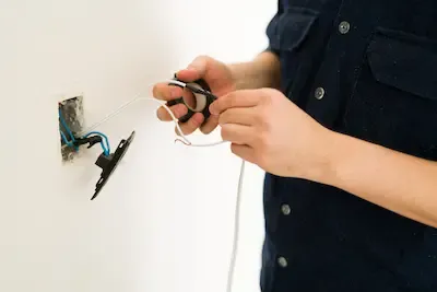 Tecnico che ripara un punto elettrico danneggiato